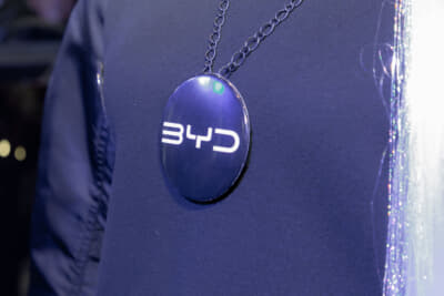 亀澤杏菜さんはBYDのロゴが入った大きなネックレスを着用